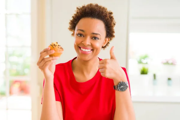 チョコチップを食べる若いアフリカ系アメリカ人女性は Okサインをやって大きな笑顔で幸せなマフィン 指で親指アップ 優れた兆候 — ストック写真