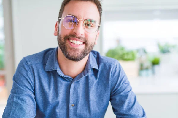 Beau homme portant des lunettes et souriant détendu à la caméra — Photo