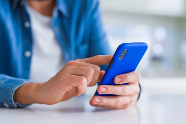 Primer plano de las manos del hombre usando el teléfono inteligente y sonriendo —  Fotos de Stock