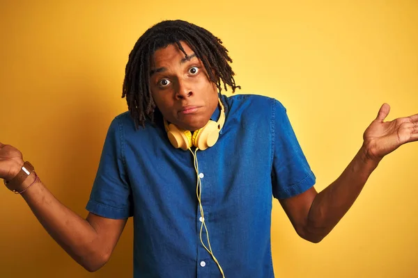 Afro American Man Dreadlocks Wearing Headphones Isolated Yellow Background Clueless — Stock Fotó