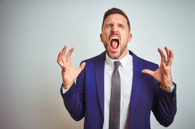 Beyaz izole arka plan üzerinde genç yakışıklı iş adamı kollarını kaldırdı ve kapalı gözleri heyecanlı çığlık ile başarı için deli ve deli kutluyor. Kazanan kavramı