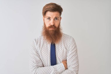 Genç kızıl saçlı İrlandalı işadamı izole beyaz arka plan şüpheci ve sinir üzerinde duran, çapraz kolları ile yüzünde ifade onaylamayan. Negatif kişi.