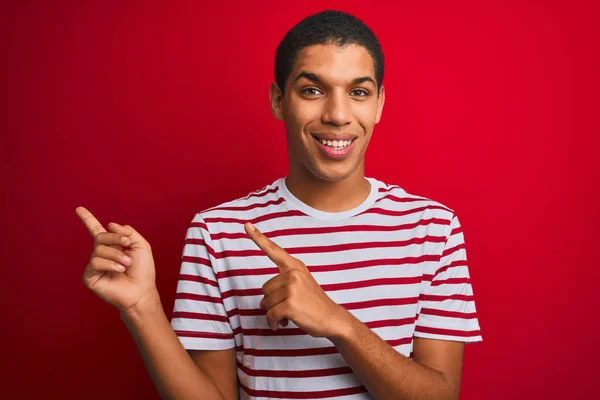 Jonge Knappe Arabische Man Draagt Gestreepte Shirt Geïsoleerde Rode Achtergrond — Stockfoto