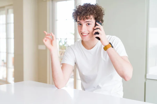 Joven Hablando Por Teléfono Casa Muy Feliz Señalando Con Mano — Foto de Stock