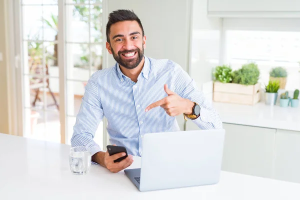 Przystojny Hiszpan Człowiek Biznesu Pomocą Laptopa Smartfona Bardzo Szczęśliwy Wskazując — Zdjęcie stockowe