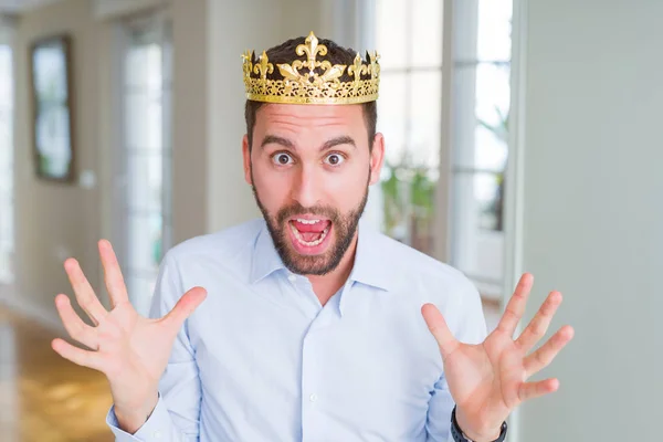 英俊的商人戴着金冠作为国王或王子庆祝疯狂和惊讶的成功与手臂抬起和睁开眼睛尖叫兴奋 优胜者概念 — 图库照片