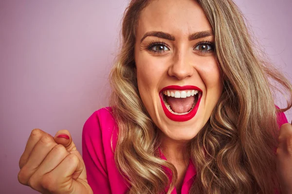 Young beautiful woman wearing elegant shirt standing over pink isolated background screaming proud and celebrating victory and success very excited, cheering emotion