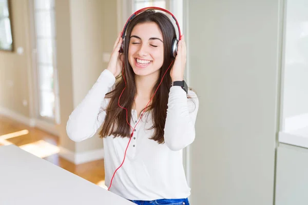 Hermosa mujer joven con auriculares escuchando música, enj — Foto de Stock