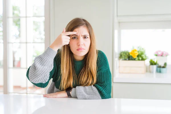 Genç güzel artı boyutu kadın alnına sivilce, siyah çirkin enfeksiyon mutsuz işaret rahat çizgili kazak giyiyor. Akne ve cilt sorunu
