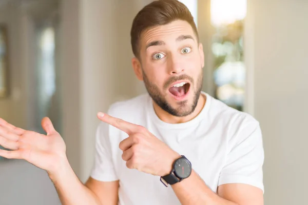 Jovem Bonito Homem Vestindo Casual Branco Shirt Casa Espantado Sorrindo — Fotografia de Stock