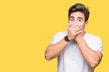 Üzerinde beyaz t-shirt giyen genç yakışıklı adam arka plan ağız hata için elleriyle kapsayan şok izole. Gizli kavramı.
