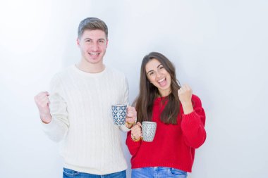 Beyaz izole arka plan üzerinde Güzel genç çift gurur çığlık ve zafer ve başarı çok heyecanlı kutluyor, duygu tezahürat bir fincan kahve içme
