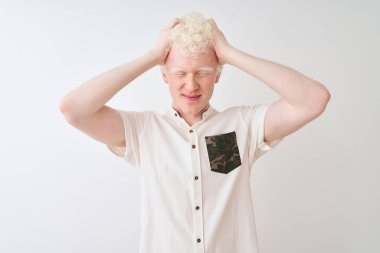 Genç albino sarışın adam rahat gömlek giyen izole beyaz arka plan üzerinde baş ağrısı umutsuz acı ve stresli çünkü ağrı ve migren. Eller baş üstünde.