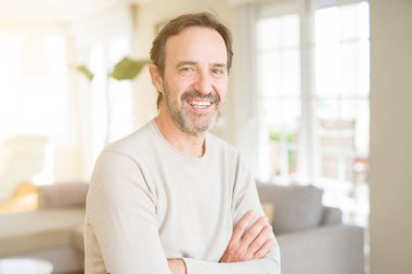 Evde kameraya bakarak gülümseyen yakışıklı orta yaş erkek