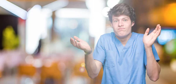 Joven Médico Con Uniforme Médico Sobre Fondo Aislado Expresión Despistada — Foto de Stock