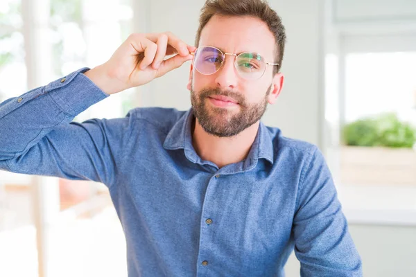 Handsome man wearing glasses and smiling relaxed at camera — Stock Photo, Image