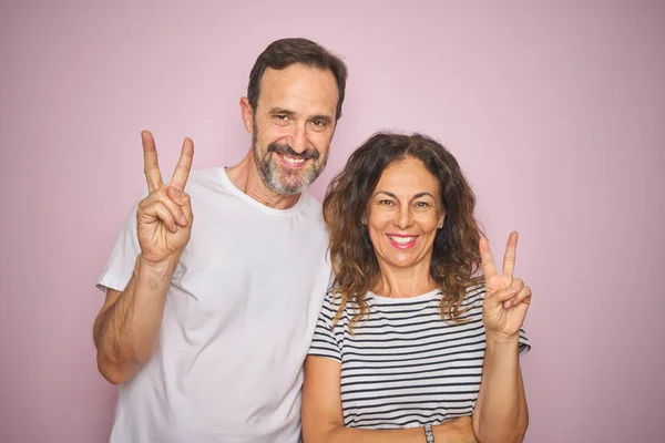 Belo Casal Meia Idade Juntos Sobre Fundo Rosa Isolado Sorrindo — Fotografia de Stock