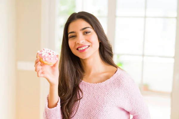 Jeune belle femme mangeant rose savoureux donut souriant — Photo