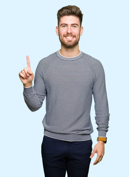 Pemuda Tampan Yang Mengenakan Sweater Garis Garis Menunjukkan Dan Menunjuk — Stok Foto