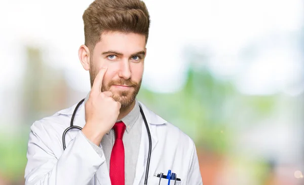Junger Gutaussehender Arzt Medizinischem Mantel Der Auf Das Auge Zeigt — Stockfoto