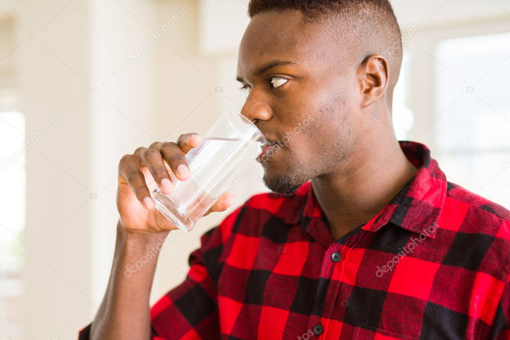 Young african american man drinking a fresh glass of water