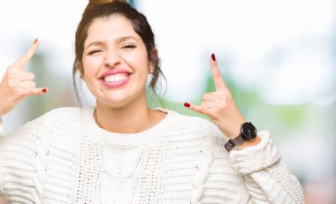 Deli ifade rock simge elle yapıyor ile kış kazak bağırarak giyen genç güzel kadın. Müzik yıldızı. Ağır kavramı.