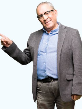 Yüzünde, kocaman bir gülümseme ile gözlük takan yakışıklı üst düzey businesss adam kameraya bakarak yan el ve parmak ile işaret.