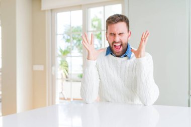 Yakışıklı adam rahat kazak giyen kollarını kaldırdı ve kapalı gözleri heyecanlı çığlık ile başarı için deli ve deli kutluyor. Kazanan kavramı