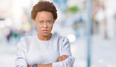 Young beautiful african american woman wearing glasses over isolated background skeptic and nervous, disapproving expression on face with crossed arms. Negative person. clipart