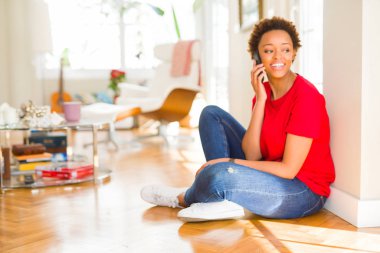 Güzel genç African Amerikan kadın oturma üzerinde the zemin havi