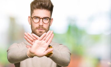 Gözlük takan genç yakışıklı iş adamı ret ifadesi geçiş silah ve avuç içi negatif işareti, öfkeli yüz yapıyor