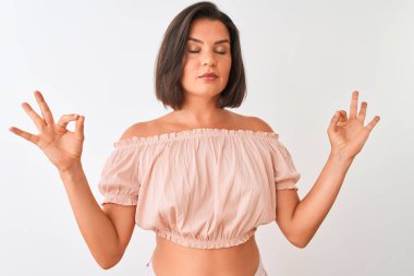 Genç güzel kadın izole beyaz arka plan üzerinde duran rahat t-shirt giyen rahat rahat ve gözleri parmakları ile meditasyon jest yapıyor kapalı gülümseyerek. Yoga konsepti.