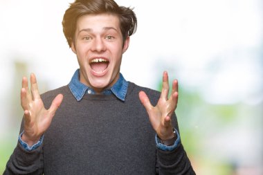 Genç yakışıklı zarif adam deli kutluyor ve silah ile başarı için heyecanlı çığlık kaldırdı ve açık gözleri hayret izole arka plan üzerinde. Kazanan kavramı