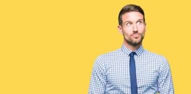 Güzel bir iş adamı kravatı giyen gülümseyen yan bakıyor ve düşünmek.