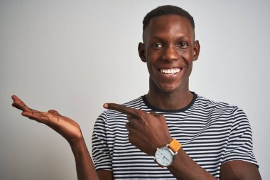 Izole beyaz arka plan üzerinde duran lacivert çizgili t-shirt giyen Afrikalı Amerikalı adam el ve parmak ile işaret çok mutlu