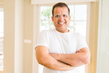 Evde kameraya gülümseyen gözlük takan orta yaş erkek