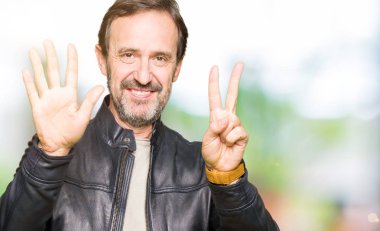 Gösterilen ve parmakları ile işaret siyah deri ceket giyen orta yaş yakışıklı adam kendinden emin ve mutlu gülümseyerek süre yedi numara.