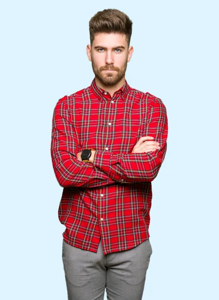 Yakışıklı delikanlı şüpheci ve sinir, onaylamayan ifade yüz çapraz kolları üzerinde. Negatif kişi.