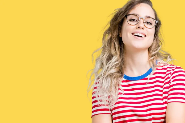 Güzel genç sarışın kadın üzerinde gözlük ile mutlu yüz gülümseyerek kameraya seyir silah geçti arka plan izole. Olumlu bir kişi.