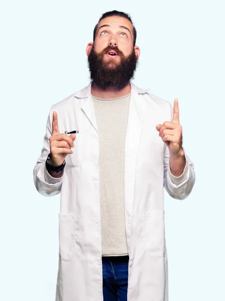 Νεαρό Ξανθό Επιστήμονα Άνθρωπος Φορώντας Λευκό Παλτό Κατάπληκτος Και Έκπληκτος — Φωτογραφία Αρχείου