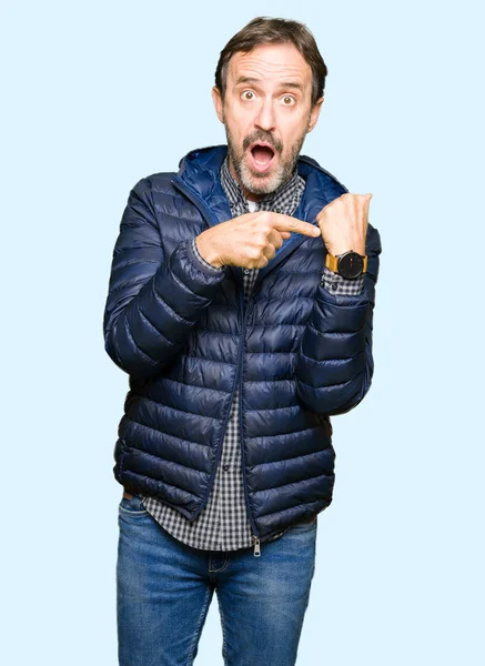 Orta yaş yakışıklı adam acele işaretleme izlemek için zaman, sabırsızlık, üzgün ve kızgın son tarih gecikme için kış palto giyiyor