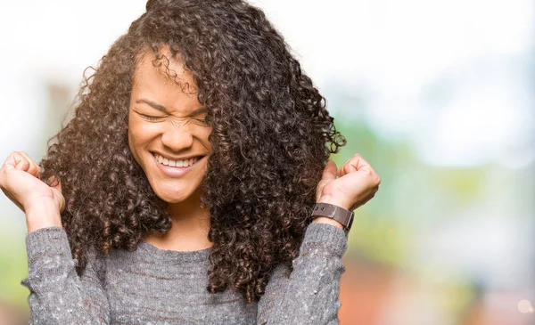 Joven Mujer Hermosa Con Pelo Rizado Usando Suéter Gris Celebrando —  Fotos de Stock