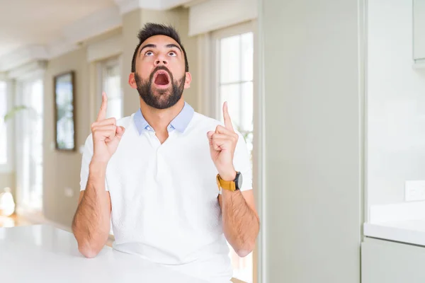 Hombre Hispano Guapo Casual Camiseta Blanca Casa Asombrado Sorprendido Mirando —  Fotos de Stock