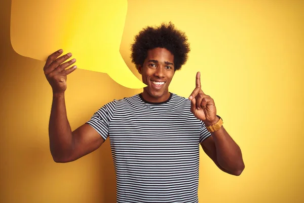노란색 서있는 거품을 들고있는 아프리카 미국인 남자가 행복한 얼굴로 손가락을 — 스톡 사진