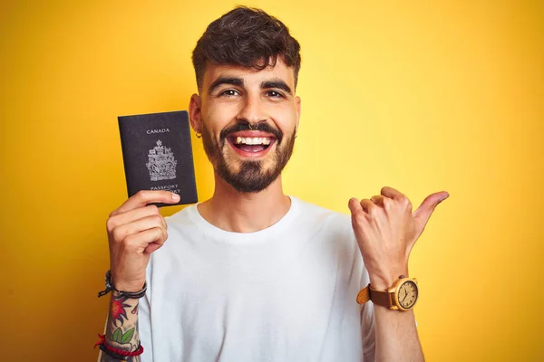 Mladý Muž Tetováním Který Nosí Cestovní Pas Kanady Izolované Žluté — Stock fotografie