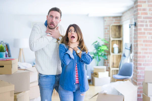 Young Beautiful Couple Standing New Home Cardboard Boxes Shouting Suffocate — Stock Photo, Image