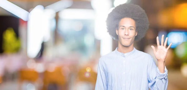 アフロの髪を指で上向きの表示と若いアフリカ系アメリカ人の数は自信を持って 幸せな笑みを浮かべている間 — ストック写真