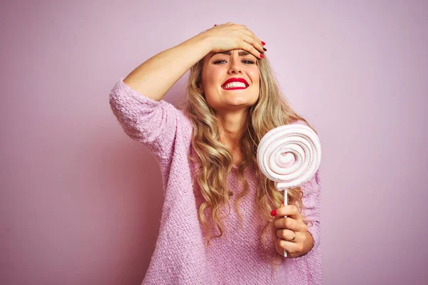 Νέα Όμορφη Γυναίκα Τρώει Γλυκό Καραμέλα Πάνω Από Ροζ Απομονωμένο — Φωτογραφία Αρχείου