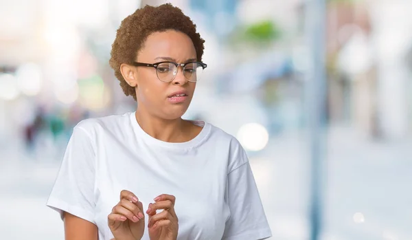 Beautiful young african american woman wearing glasses over isolated background disgusted expression, displeased and fearful doing disgust face because aversion reaction. With hands raised. Annoying concept.