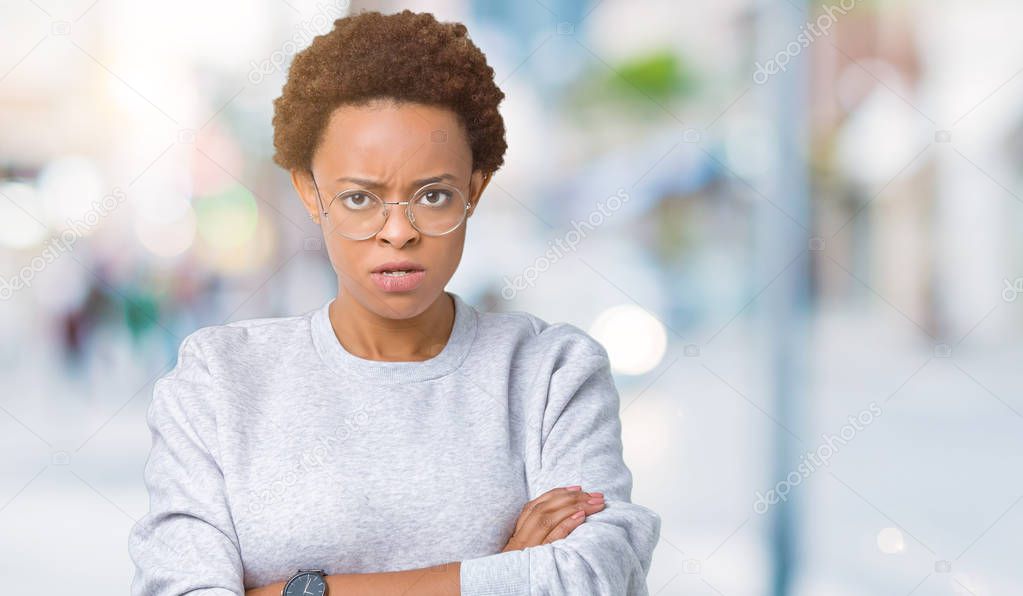Young beautiful african american woman wearing glasses over isolated background skeptic and nervous, disapproving expression on face with crossed arms. Negative person.